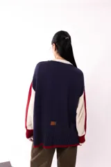 Buzo oversized en color crudo, con texturas y mezcla de colores, presenta costuras a mano y bolsillo delantero.