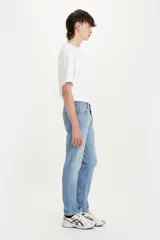 Jean de denim celeste claro con rotura en la rodilla, corte slim fit y tiro medio.