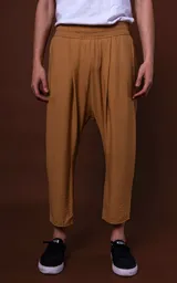Pantalón color camel de corte holgado, largo a la pantorrilla y cintura elástica con cordón ajustable.