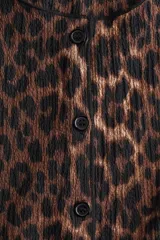 Chaleco de punto con estampado animal print, cuello redondo y cierre frontal con botones.