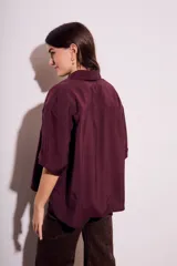 Camisa oversize color borgoña de mangas cortas con puños doblados y bolsillo en el pecho.