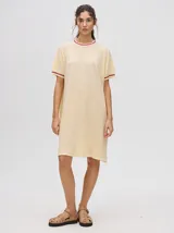 Vestido corto color crema con cuello redondo y mangas cortas con puños a rayas color borgoña.