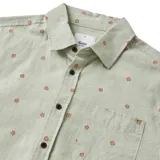 Camisa beige de manga corta con estampado floral en color ladrillo, cuello clásico y bolsillo en el pecho. Cierre frontal con botones marrones.
