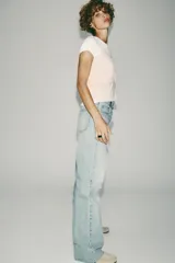 Pantalón de jean gris de corte wide leg, tiro alto y largo hasta el tobillo.