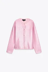 Chaqueta de lentejuelas rosa con cuello redondo, manga larga y cierre frontal con botones.