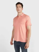 Chomba de piqué color salmón, de corte clásico, con cuello polo y tapeta de dos botones.