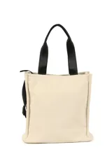 Bolso tote color beige con doble asa de mano negra y correa bandolera negra ajustable. Tiene un bolsillo externo con cierre y un logo estampado en la base.