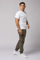 Pantalón cargo color beige de gabardina, con corte ajustado, bolsillos laterales con fuelle y puños elásticos en los tobillos.