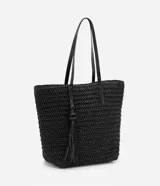 Bolso de playa negro tejido en paja de papel, con asas de hombro en cuero sintético y detalle de borla colgante.