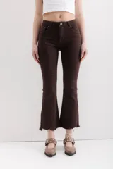 Pantalón jean marrón acampanado con detalle desflecado en el bajo y tiro medio.