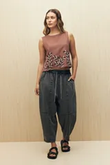 Pantalón gris oscuro de denim con corte holgado, cintura elastizada con cordón y ruedo con dobladillo.