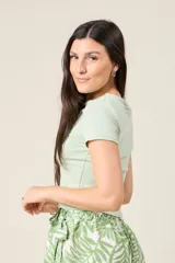 Remera corta color beige de corte ajustado y mangas cortas.