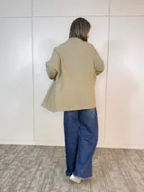 Saco tejido color camel, de corte largo y diseño de tejido abierto.