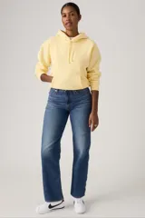 Jean azul de corte recto y tiro alto, con lavado medio y efecto desgastado en los muslos.