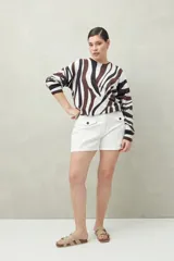 Short blanco de tiro alto con bolsillos delanteros con solapa y botones a la vista.