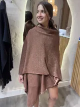 Ruana tejida de punto color marrón cobrizo con hilos de lurex que le dan un brillo sutil. Diseño amplio y asimétrico.