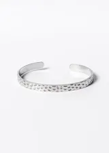Pulsera esclava abierta de acero quirúrgico con textura martillada.
