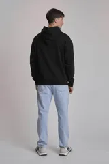 Buzo negro con capucha y bolsillo tipo canguro.