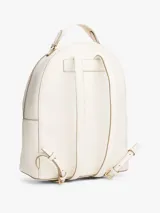 Mochila Tommy Hilfiger color blanco con detalles en dorado. Tiene un compartimento principal con cierre de cremallera, un bolsillo frontal con cierre, asa superior y correas ajustables.