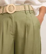 Pantalón wide leg verde oliva de cintura alta, confeccionado en viscolino, con trabillas en la cintura, cierre tradicional y pliegues. Incluye cinturón de rafia artificial.
