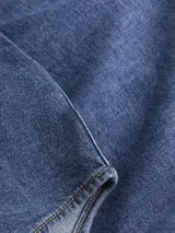 Camisa de denim azul de corte slim fit, con cuello clásico, cierre frontal con botones blancos y mangas largas. Confeccionada en algodón con elastano.