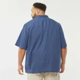 Camisa azul de manga corta con cuello clásico y cierre frontal con botones. Corte holgado.