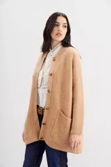 Tapado color beige de tejido de hilado suave y mullido, con calce relajado, mangas largas, cuello redondo y botones a tono.