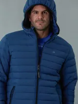 Campera acolchada azul con capucha, cierre frontal con cremallera y bolsillos laterales con cremallera. Diseño ligero y funcional. Marca Calvin Klein.