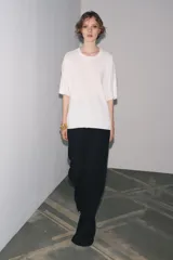 Remera blanca de punto liso, corte amplio, cuello redondo y manga corta.