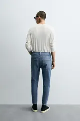 Pantalón de jean color beige, corte skinny, tiro medio, largo cropped y cinco bolsillos.