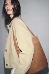 Bolso tipo maxi saca color marrón claro, de cuero trenzado, con asa de hombro y bolsillo interior.