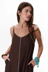 Vestido largo color crudo con breteles finos y costuras a la vista en color azul.