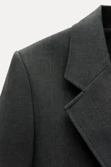 Blazer recta confeccionada en hilatura con viscosa, color gris oscuro. Tiene cuello solapa de muescas, manga larga con abertura y botones, bolsillos de plastrón en delantero, forro interior a tono y cierre frontal con botones.