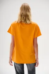 Remera color naranja con estampado floral en tonos rosa y fucsia, con la palabra "LAMODE" en relieve y contorno de labios.