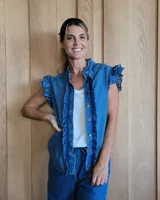 Chaleco de jean celeste con volados en los bordes y botones frontales.