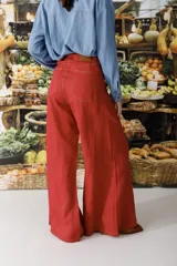 Pantalón de lino color crudo con finas rayas verticales negras, corte wide leg y tiro alto.