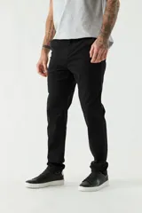 Pantalón chino color beige, de corte slim, con bolsillos laterales y traseros. Se ajusta a la cintura con cinturón de cuero marrón.