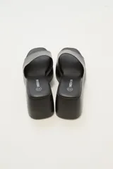 Sandalias negras con plataforma y tira ancha sobre el empeine.