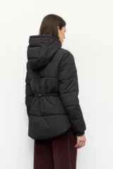Campera puffer larga color beige con capucha, cierre frontal con botones a presión, bolsillos laterales y puños elastizados.