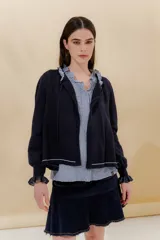Saco tejido azul marino con cuello redondo, cierre frontal con botones y detalle de volados en cuello y puños.