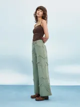 Pantalón jean de tiro alto color verde oliva, corte acampanado y detalles rotos con flecos.