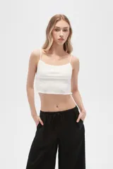 Musculosa blanca de algodón con breteles finos, punto smock, corte al cuerpo y cuello redondo.