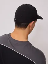 Gorra negra con logo Rusty bordado en blanco.