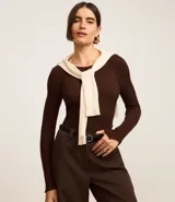 Suéter negro de punto acanalado con mangas largas y cuello redondo.