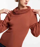 Blusa de punto color ladrillo con cuello alto boba, mangas largas con puños ajustados y detalle de hilo metalizado.