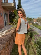 Musculosa tejida en látex metálico, con escote en V tanto en el frente como en la espalda, y detalle deshilachado en el frente.