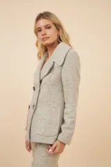 Chaquetón color crema con doble solapa, abrochadura doble, bolsillos delanteros y forro al tono.