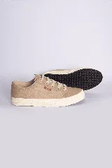 Zapatillas bajas color beige claro, con cordones y suela blanca.