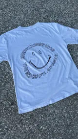 Remera blanca de algodón con estampado en la espalda con la frase "Everything's Nice" y un smiley face.