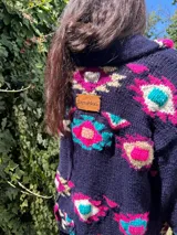 Saco de lana marrón con diseño geométrico multicolor, cuello con solapa, cierre frontal con botones y bolsillos delanteros.
